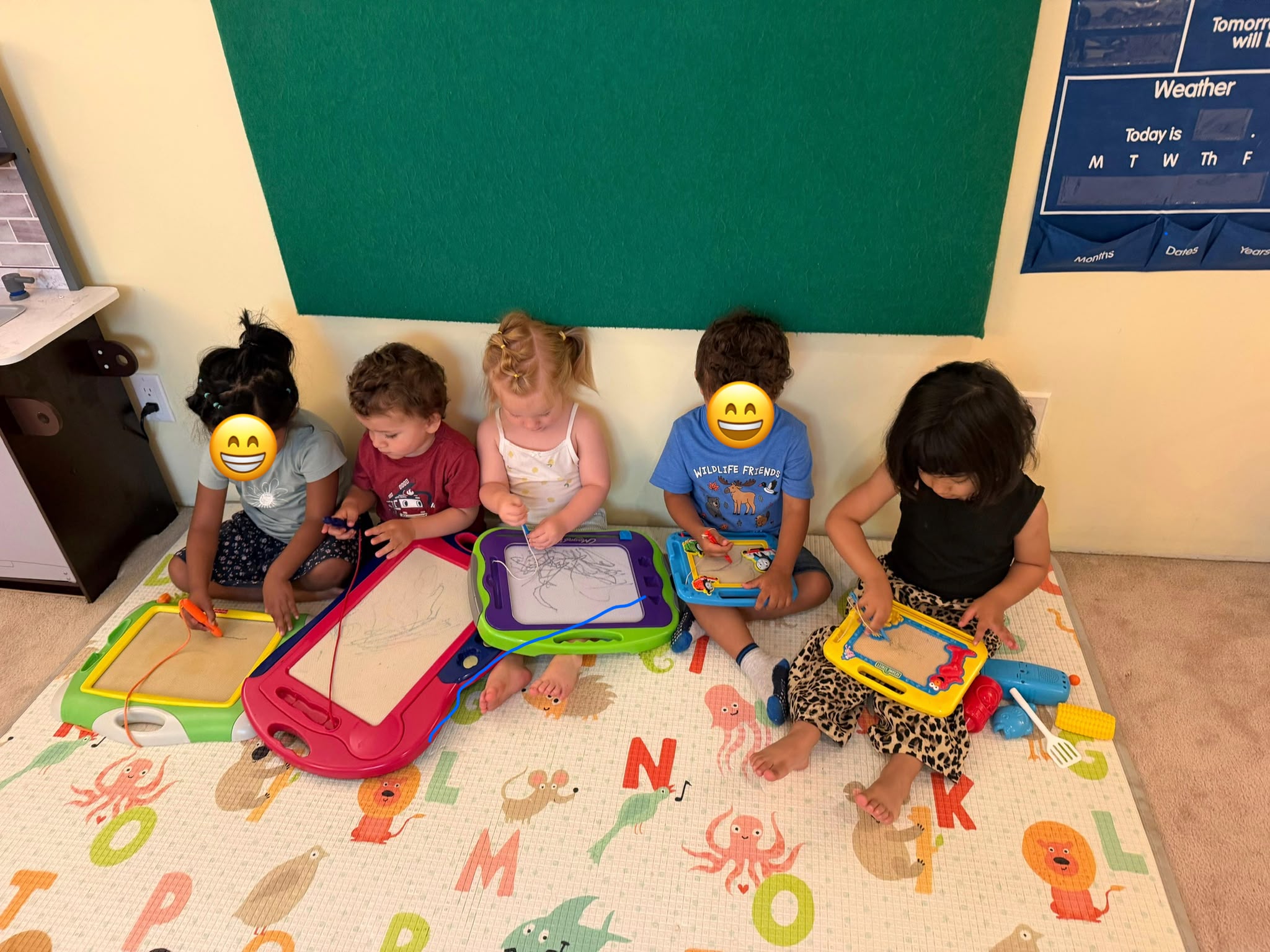 Children practicing drawing on magnetic boards