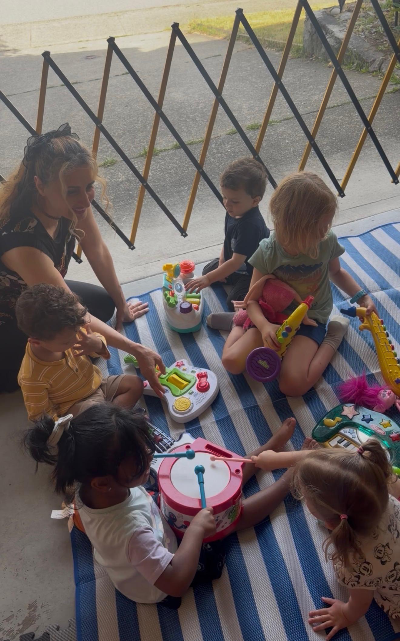 Children exploring musical toys with an educator
