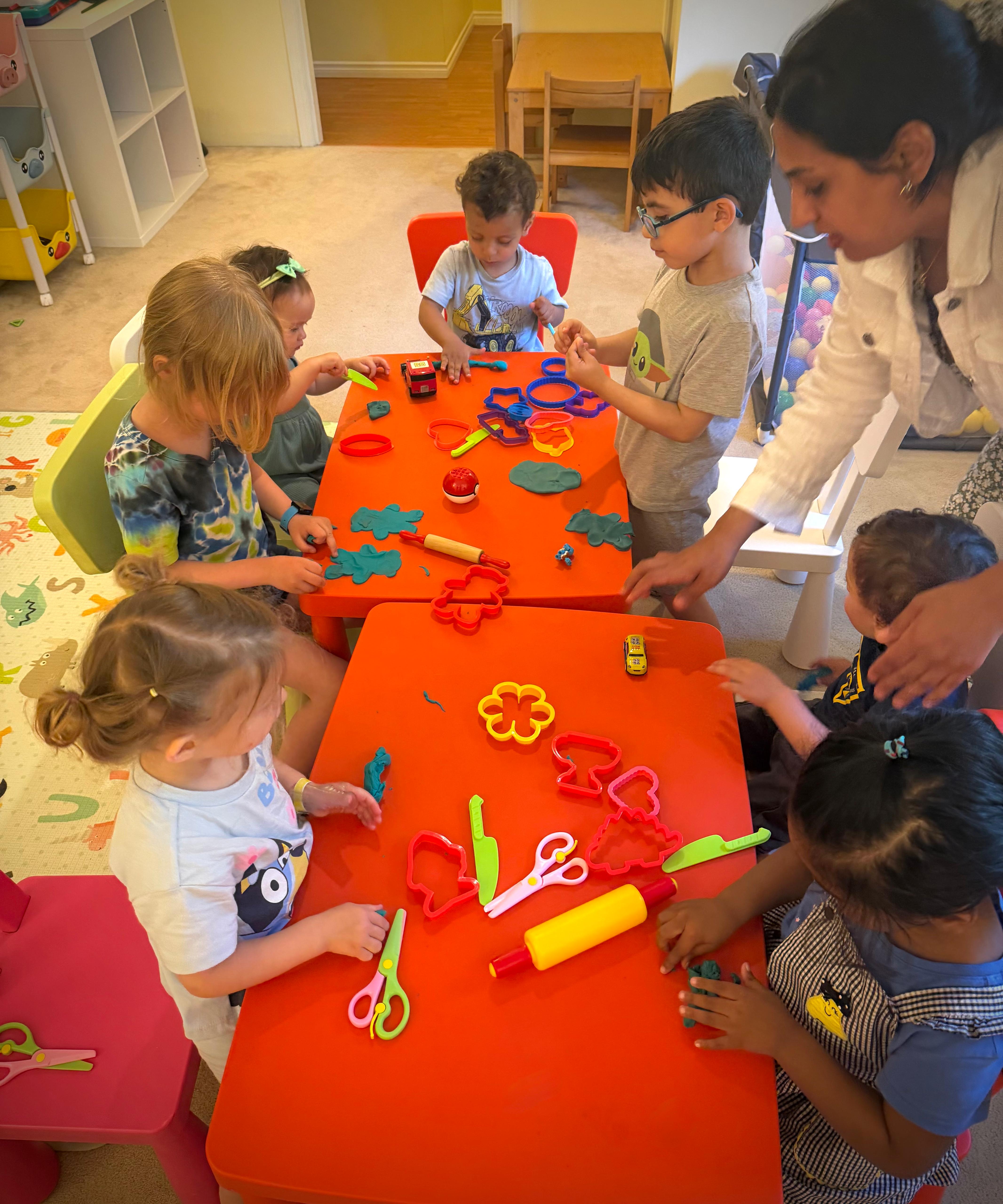 Children and educator working with play dough at the table