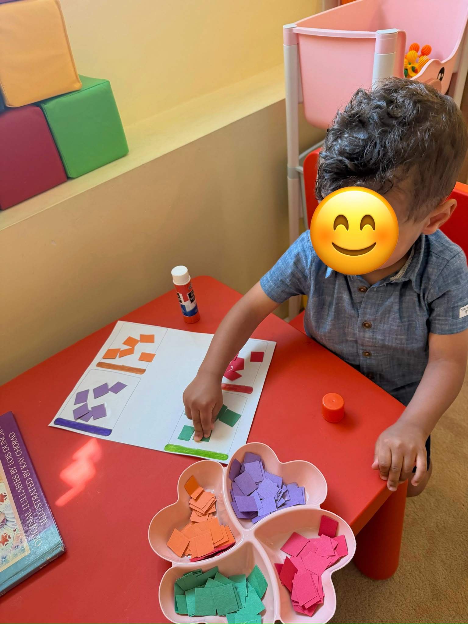 Child matching colorful paper shapes during a table activity