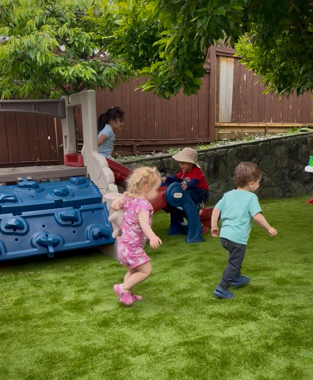 Children running and playing in the daycare backyard
