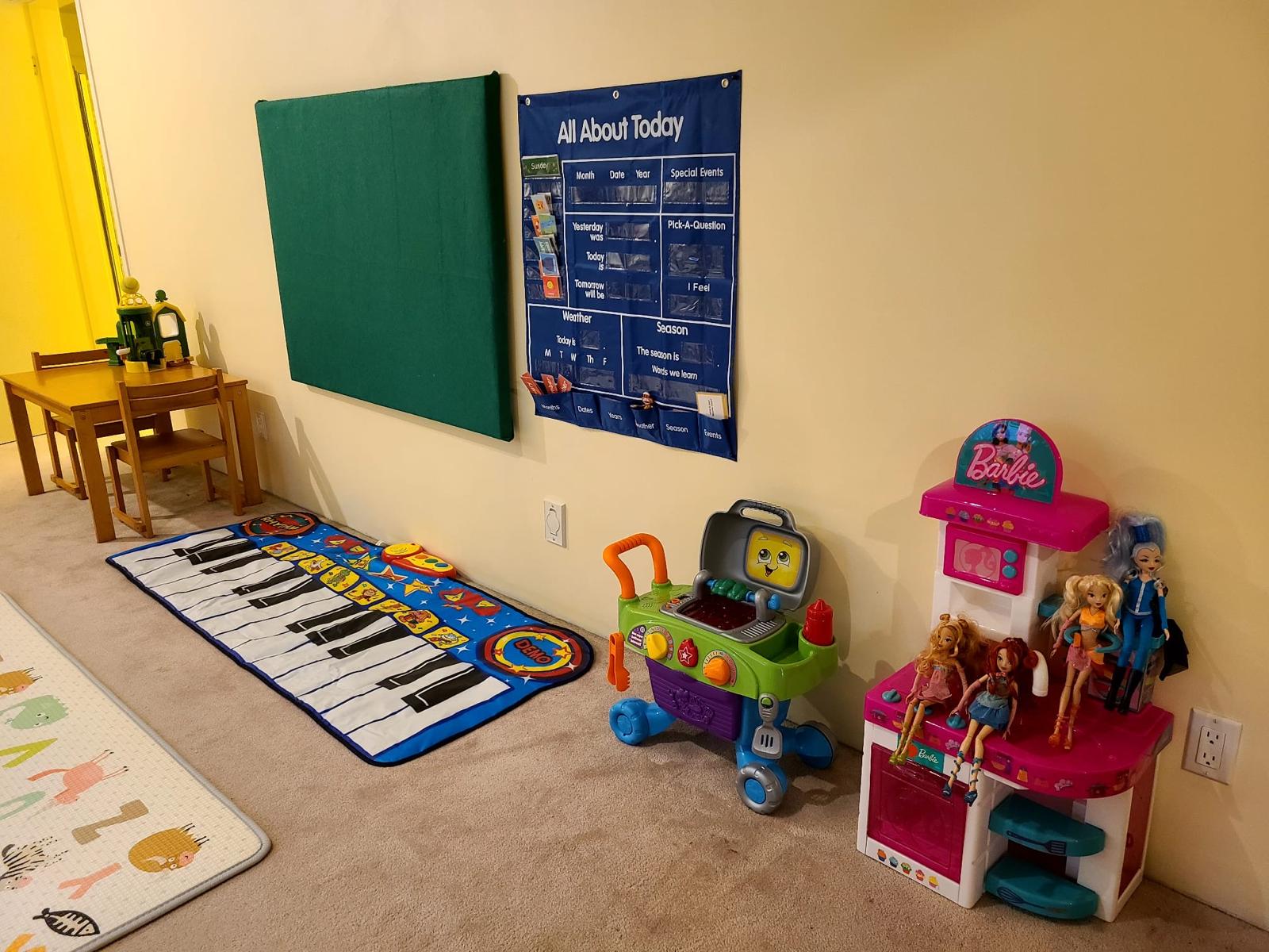Circle time wall with calendar, music mat, and pretend play toys