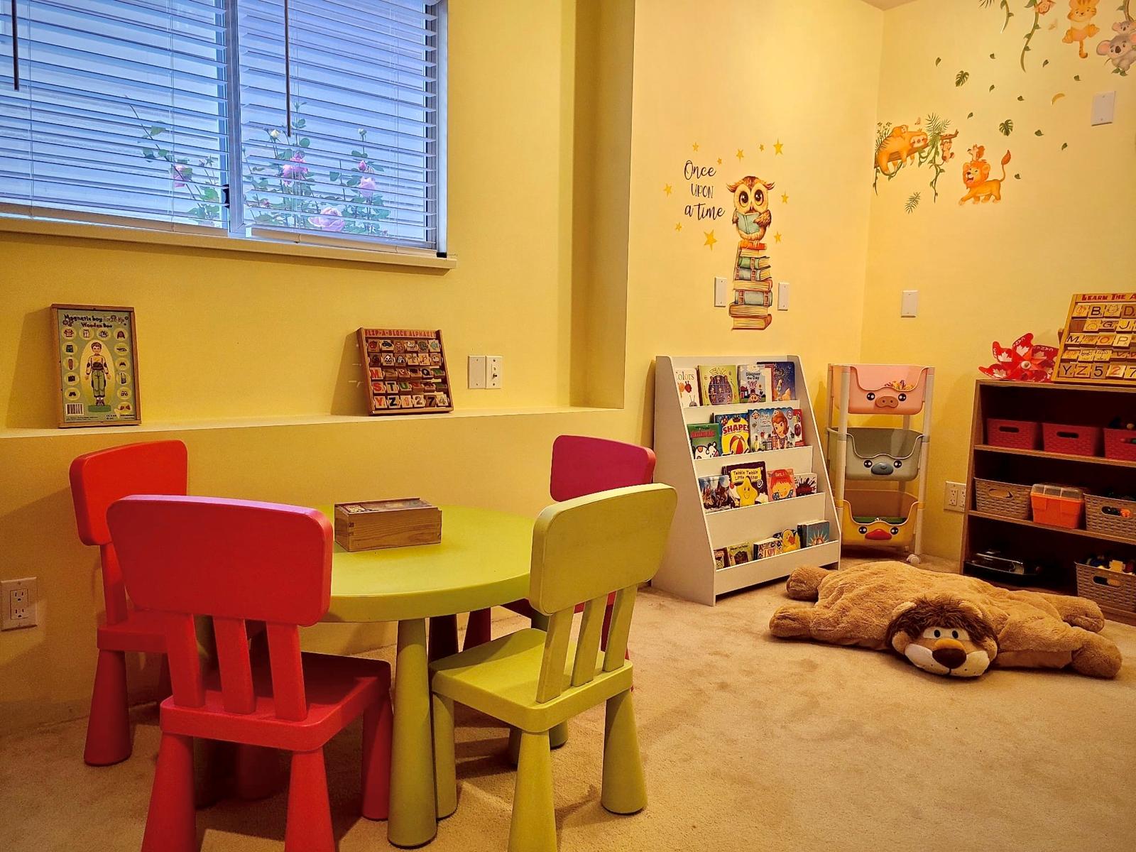 Reading corner with books, child-sized table, and cozy stuffed lion mat